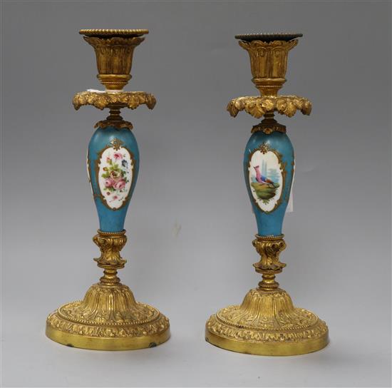 A pair of French gilt metal and porcelain candlesticks